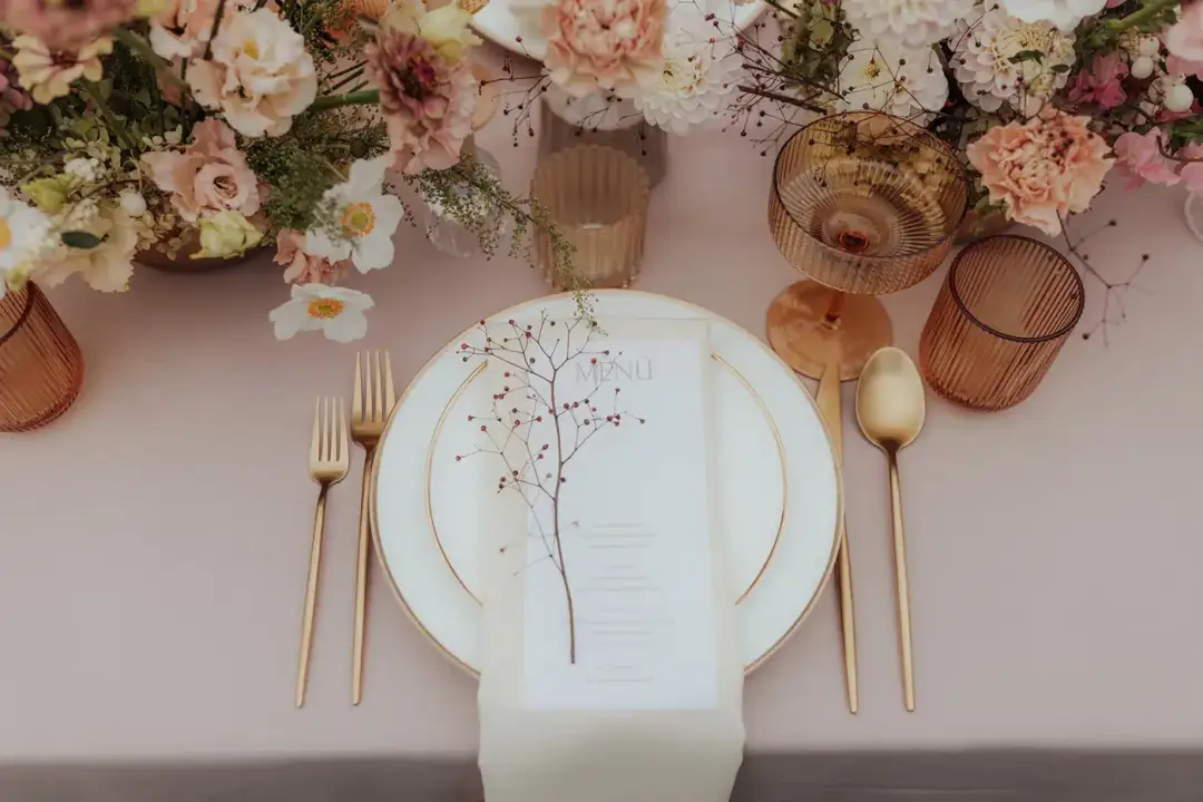 A laid table with flowers and glassware